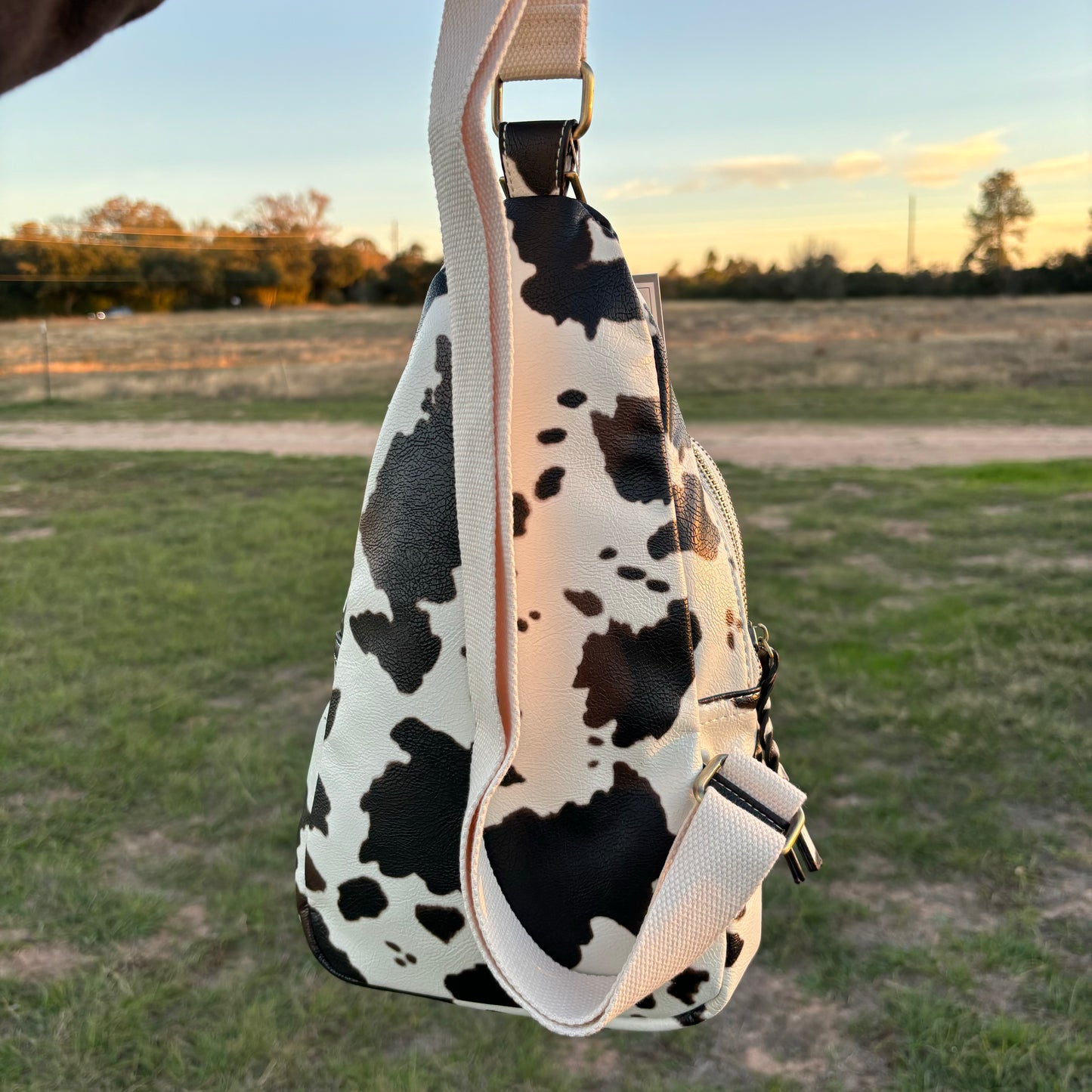 back side of cow print faux leather sling bag
